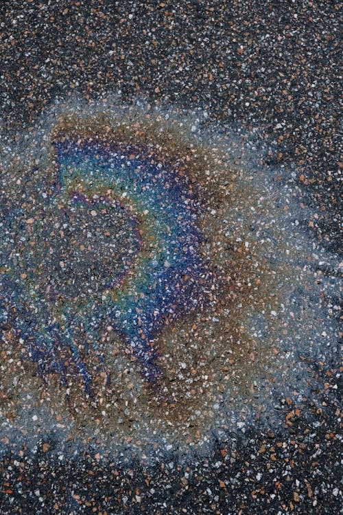 thin layer of oil on asphalt, making a rainbow